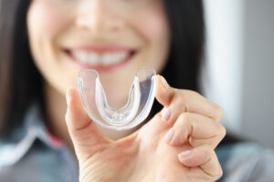 Smiling woman holds mouthguard