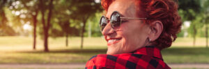 red haired woman smiling in sunglasses