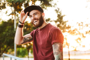 Smiling man wearing hat and airpods