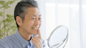 Man inspecting teeth in mirror
