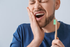 Man with toothache holding brush