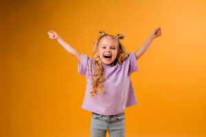 Happy girl child on orange background