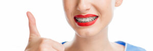 Close up portrait of a woman with tooth braces on the white background. Woman worried about a new smile with braces
