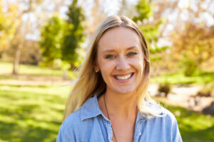 Mid thirties white woman smiling to camera in a park